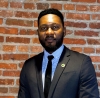 Femi Ogundolie, CPA, photo of a man in suit standing before brick wall